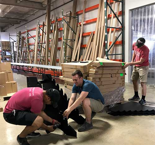 Employees build display racks for prefinished flooring samples