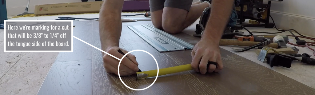 Video instructor making marks for repairing a hardwood floor board